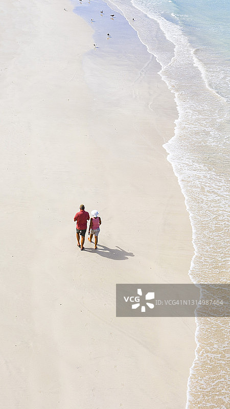夏季海滩上充满爱意的夫妇漫步（高角度拍摄）图片素材