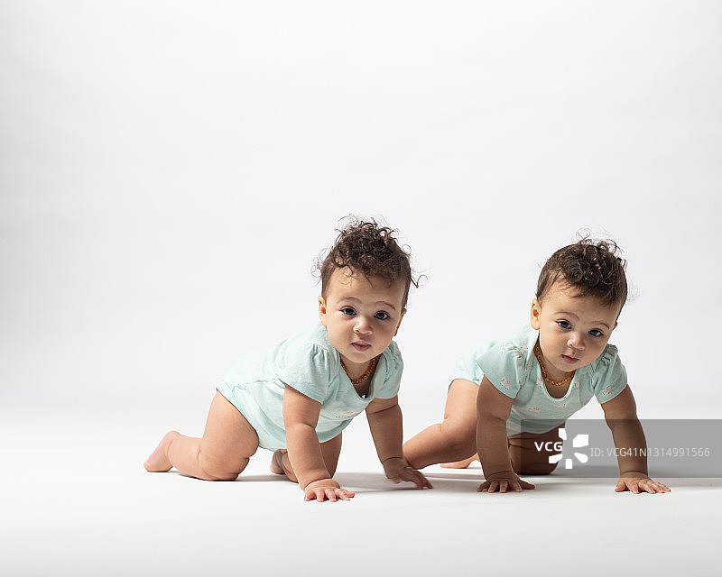 双胞胎女孩爬行看向镜头图片素材