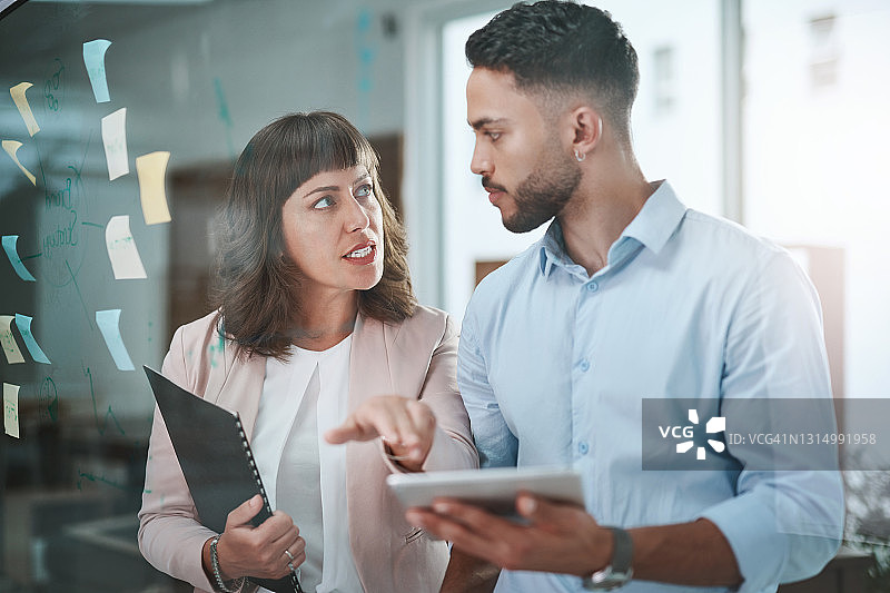 年轻商务人士在现代办公室头脑风暴时使用平板电脑图片素材