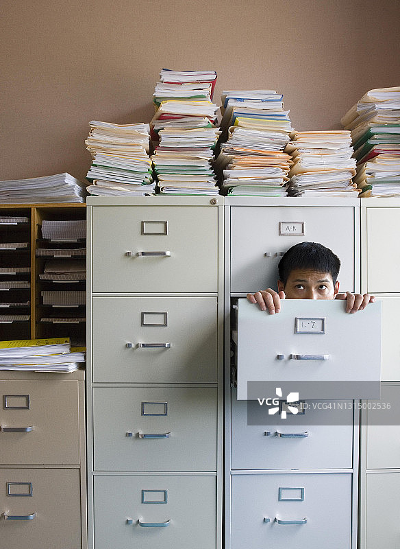 躲在文件柜里的商人图片素材