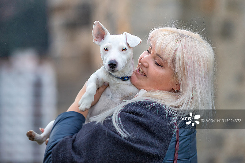 快乐的女人拥抱她的杰克罗素梗犬图片素材