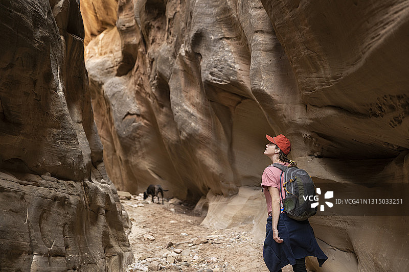 女人走在狭缝型峡谷中图片素材
