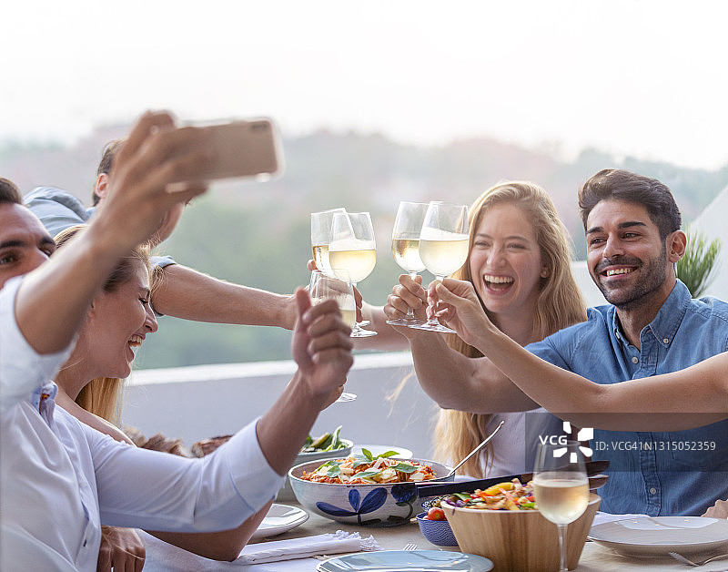 一群朋友在晚宴上用手机自拍图片素材