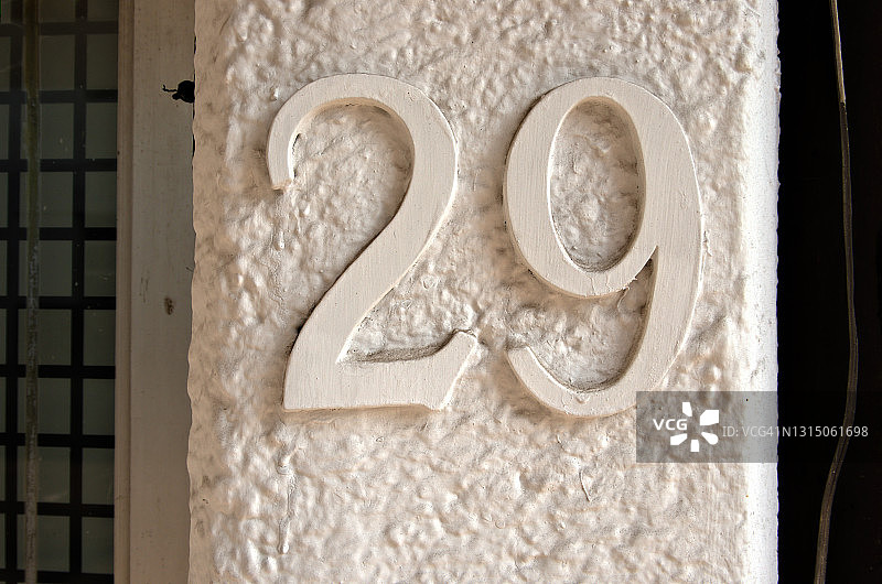 白色灰泥墙上凸起的数字29街道地址图片素材