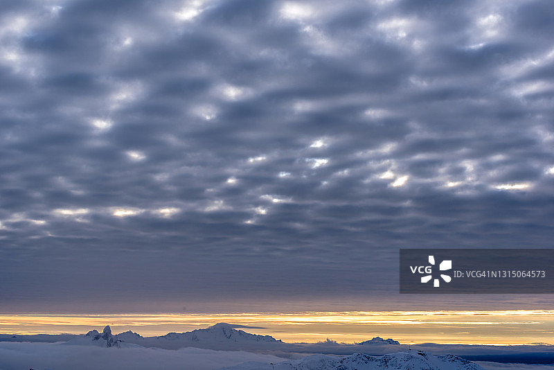 晨光照耀下的雪山和云彩图片素材