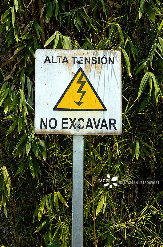 西班牙语警告标志：高压危险，请勿挖掘（竹子背景）图片素材
