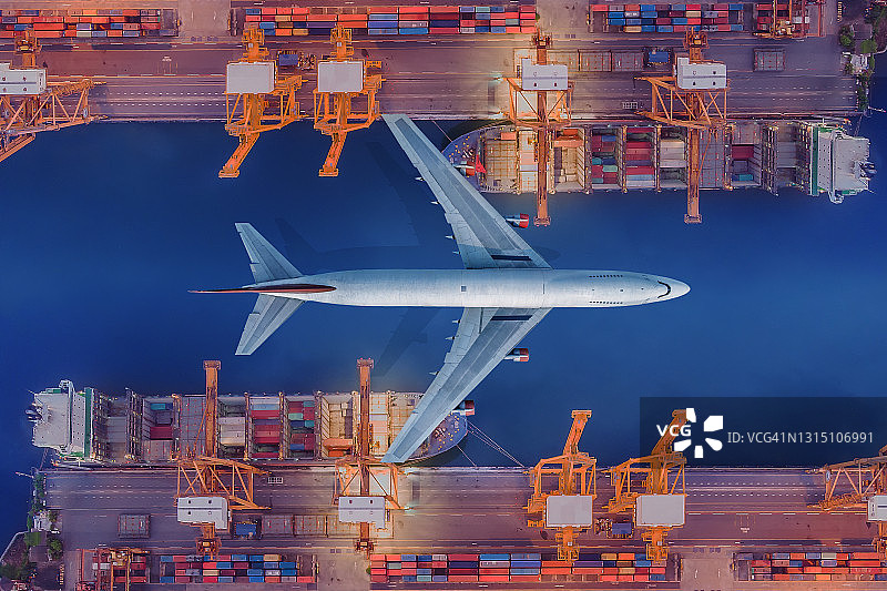 飞机飞越港口，将集装箱运到货船上，运往目的地的航拍视角图片素材