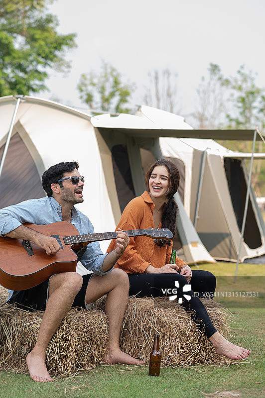 年轻情侣在露营地弹吉他图片素材