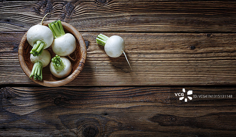 木桌橄榄木碗中的白色萝卜，食物概念，文本预留空间图片素材