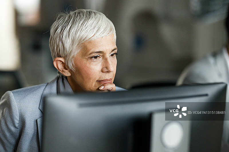 在办公室用电脑工作的有思想的女商人。图片素材