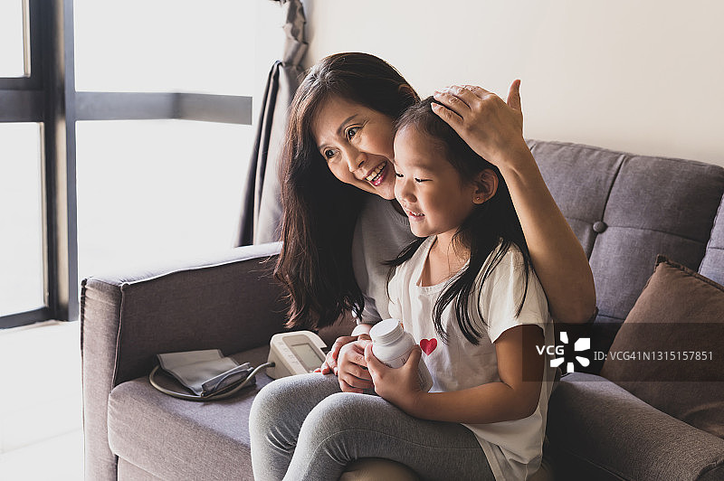 孙女在客厅为奶奶准备日常药物补充剂图片素材