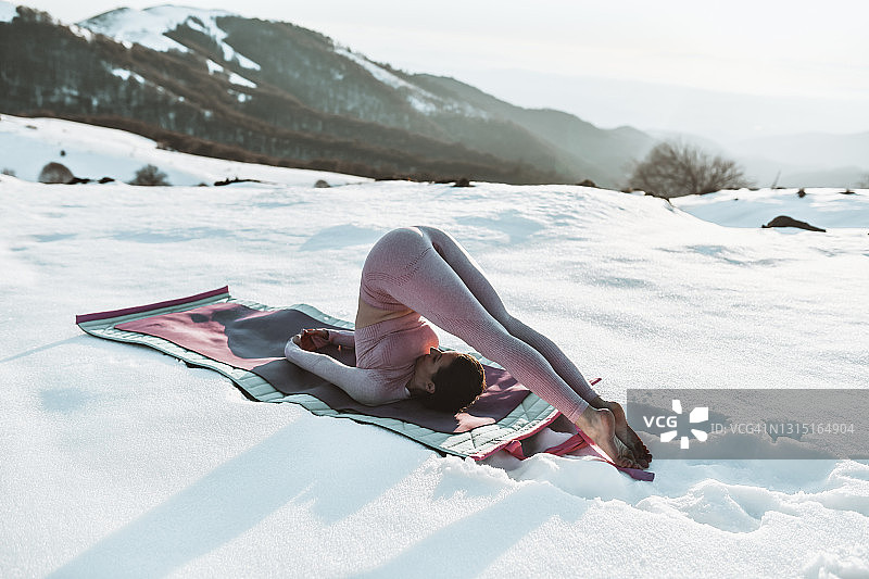 女子在山间测试柔韧性，准备进行烛台瑜伽图片素材