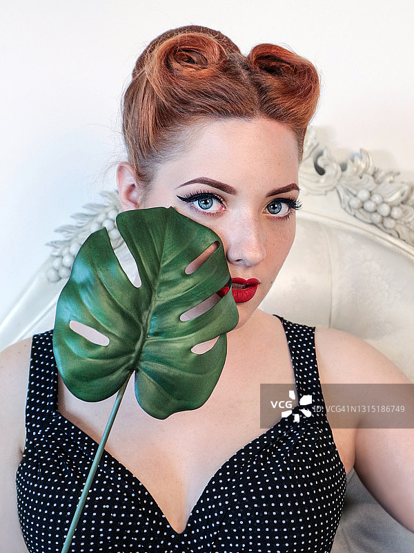 手持龟背竹叶的时尚女郎图片素材