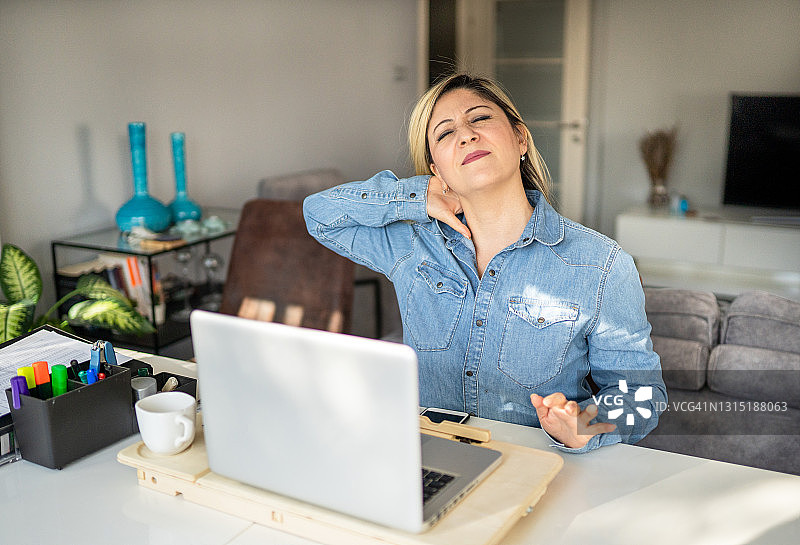 在家办公导致颈部疼痛的成年女人图片素材