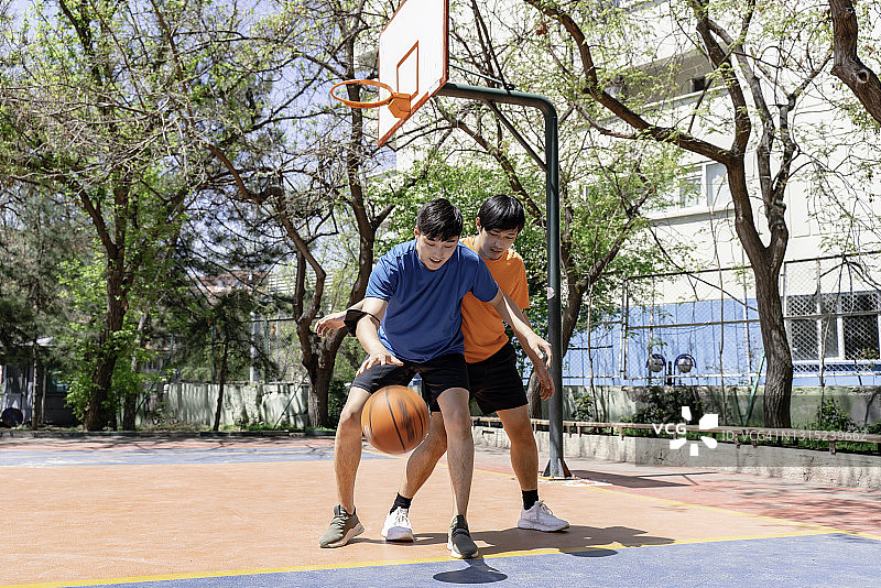 在户外打篮球的亚洲年轻男性图片素材