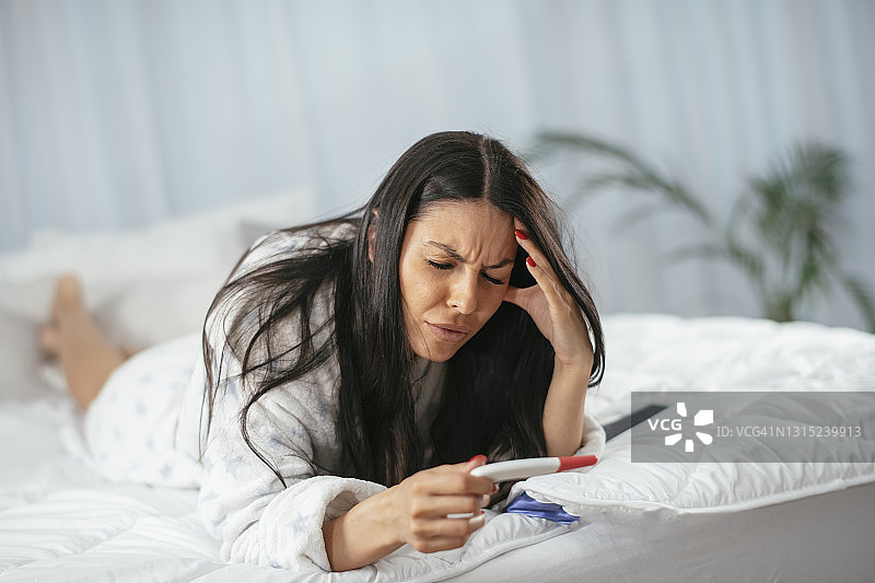 年轻女子手持验孕棒（图片）图片素材