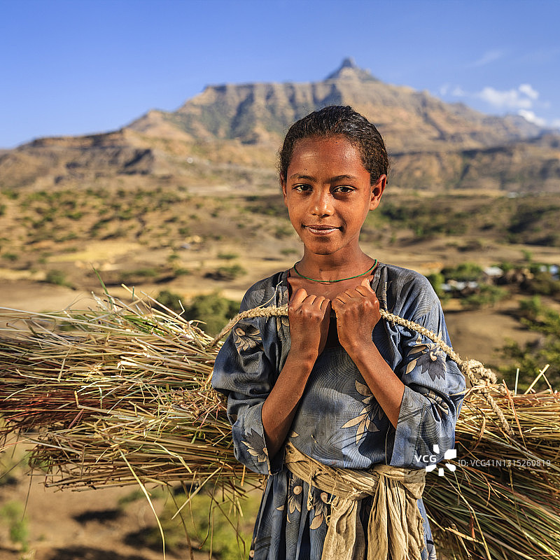 非洲东部地区携带稻草的年轻女孩肖像图片素材