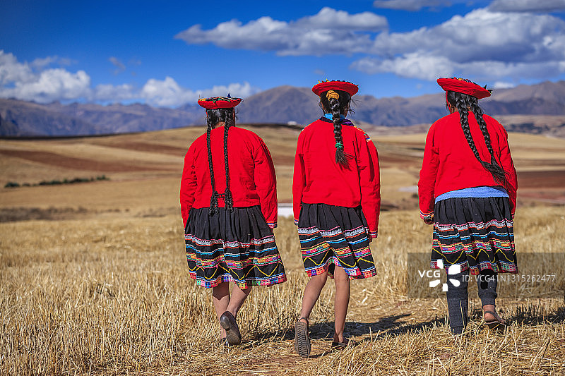 穿着民族服装的秘鲁妇女穿过神圣山谷图片素材
