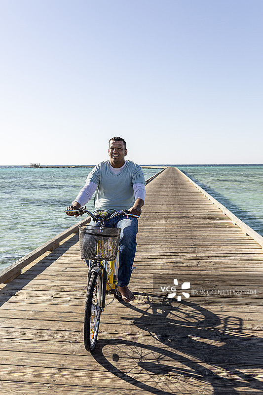 埃及男人在海滩上骑电动自行车图片素材