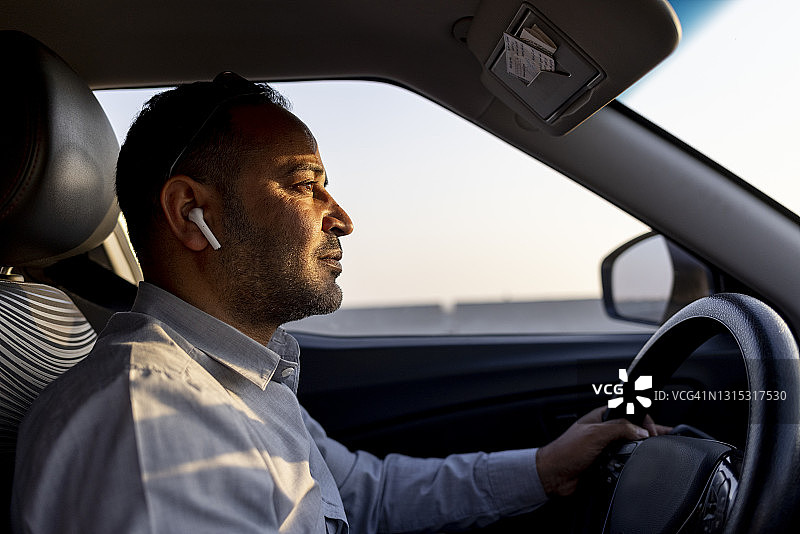 使用耳机开车的商务男士图片素材