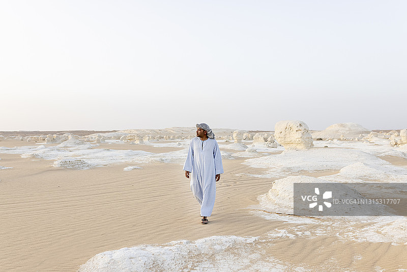 行走在白色沙漠中的埃及男子肖像图片素材