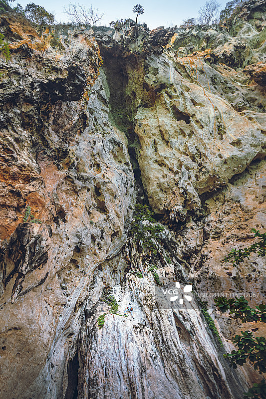 女性攀登险峻岩山的背影图片素材
