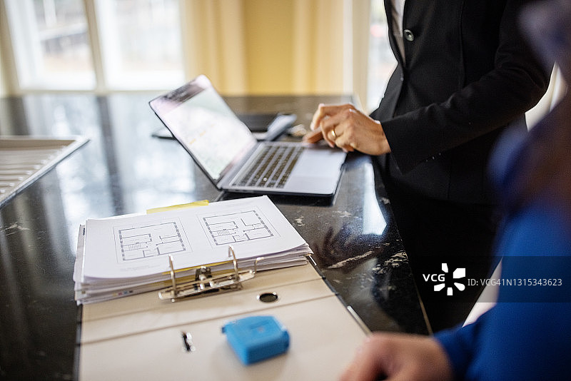 女人与房地产经纪人讨论建筑蓝图图片素材