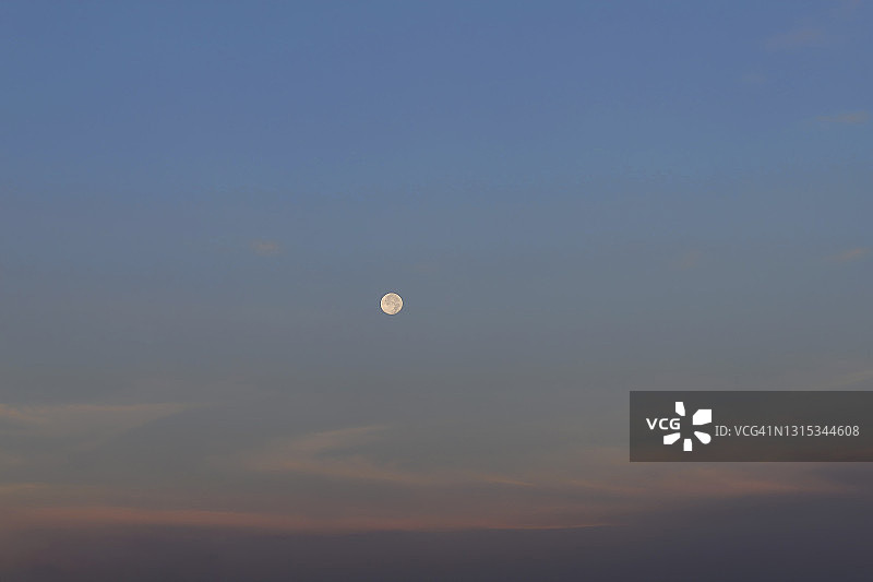 日落时分橘色云彩的美丽天空与春季月亮背景图片素材