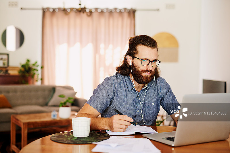 年轻商人用笔记本电脑在家工作图片素材