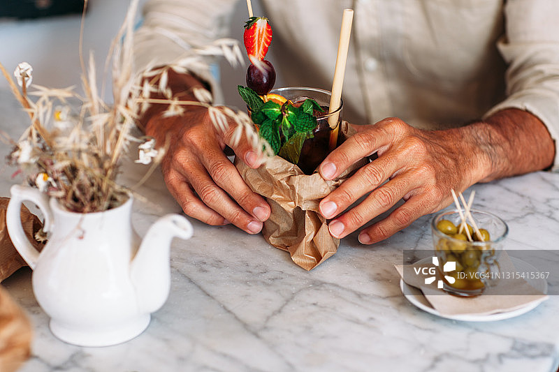 男人端着一大杯意大利味美思酒图片素材