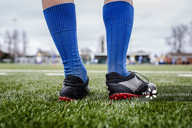 足球运动员下半身，蓝色长袜黑色训练鞋图片素材