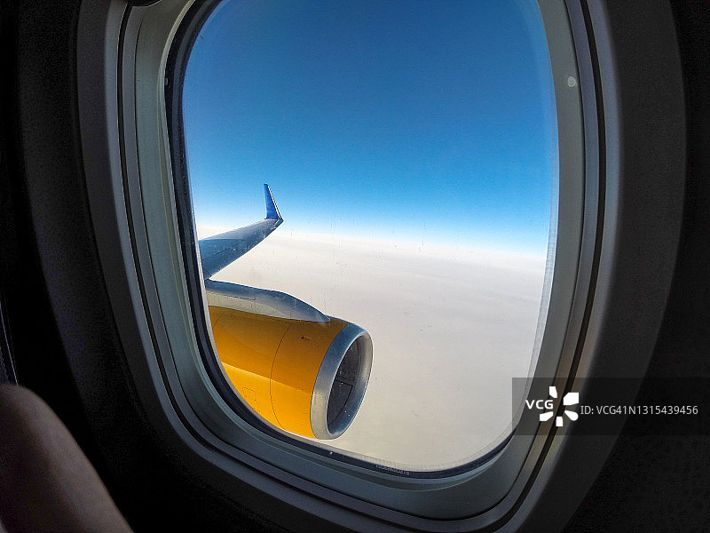 飞机舷窗外的机翼视角，有云和蓝天图片素材