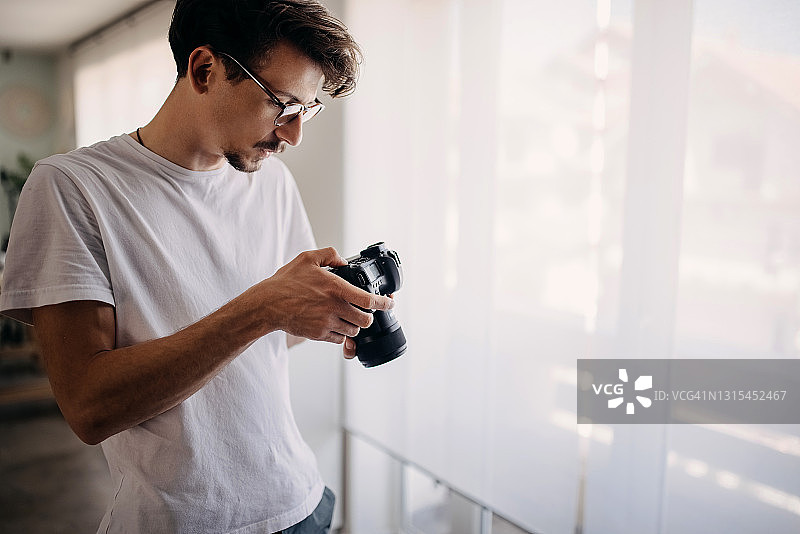 在家查看相机照片的男人图片素材