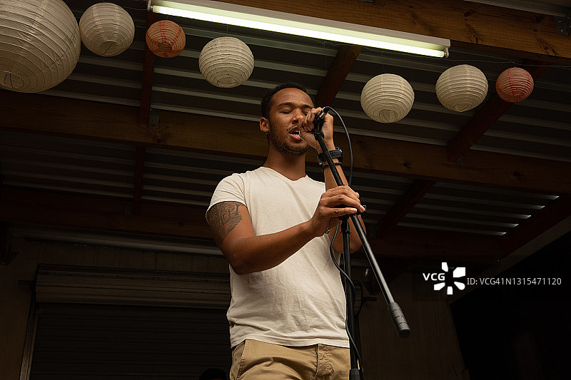充满激情地对着麦克风唱歌的年轻男人图片素材