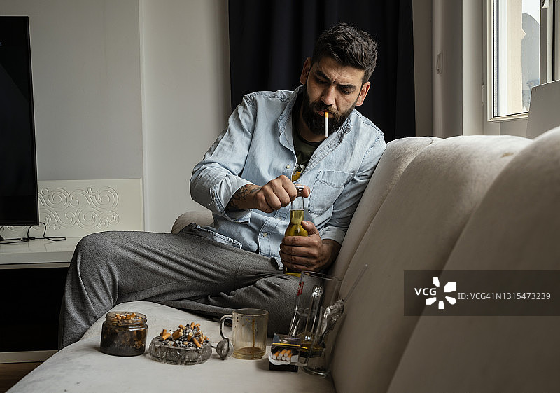 抑郁年轻男人新冠疫情期间窗边独坐图片素材