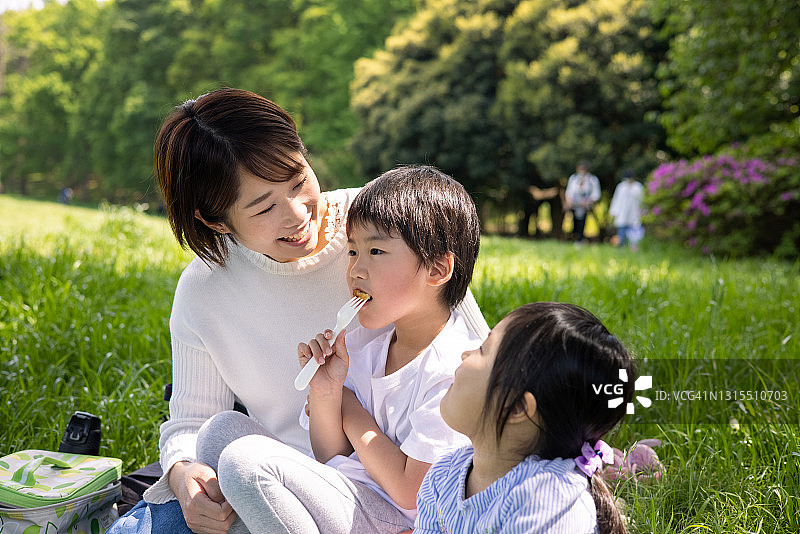 幸福的年轻家庭在公园里享用午餐图片素材