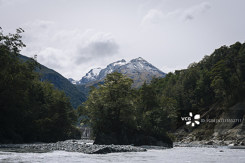 新西兰达特河畔的茂密森林和雪山图片素材