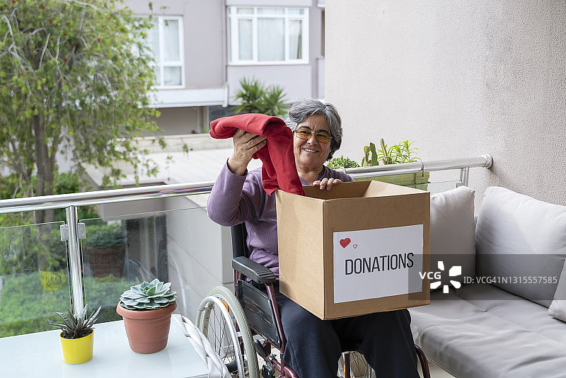 在家整理捐赠物品的老年残疾妇女图片素材