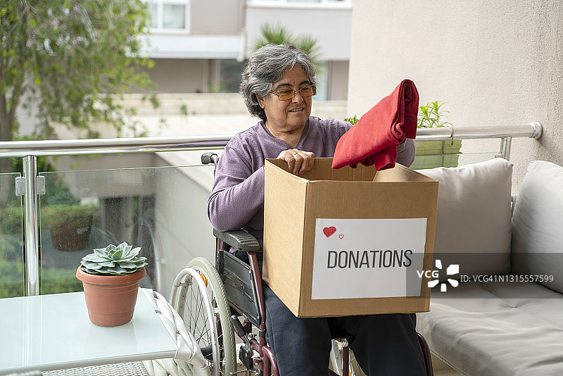在家整理捐赠物品的老年残疾妇女图片素材