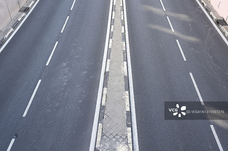 空旷的双车道高速公路，带中央隔离带的现代高速公路，通往大都市的立交桥或天桥图片素材