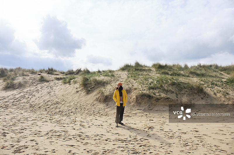 女子在有沙丘的海滩上散步度假图片素材
