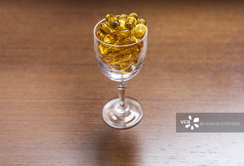 装有Omega-3胶囊的小玻璃杯图片素材