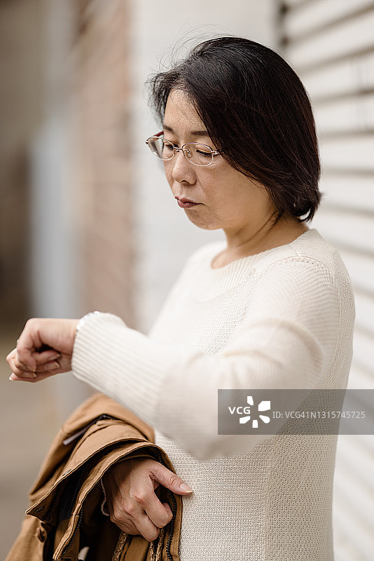 女人看着她的手表图片素材