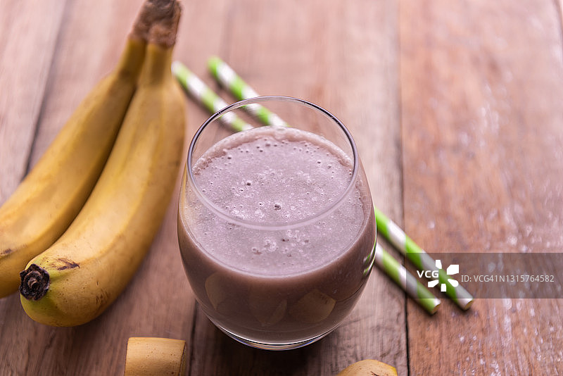 木桌上的玻璃杯香蕉奶昔图片素材