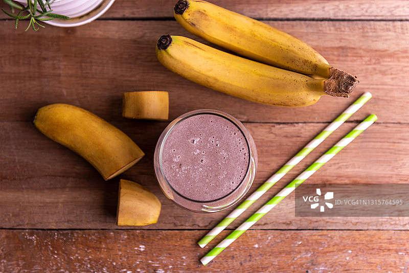 木桌上的香蕉冰沙玻璃杯（俯视）图片素材