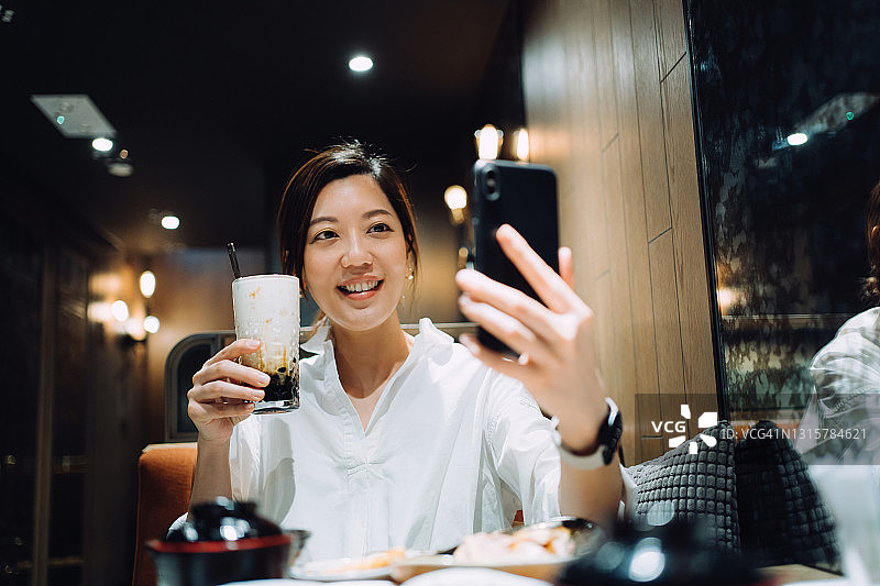 亚洲女人餐厅品尝台湾美食自拍图片素材