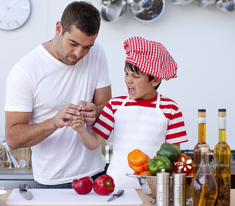 男孩在厨房切伤手指，父亲正在处理图片素材