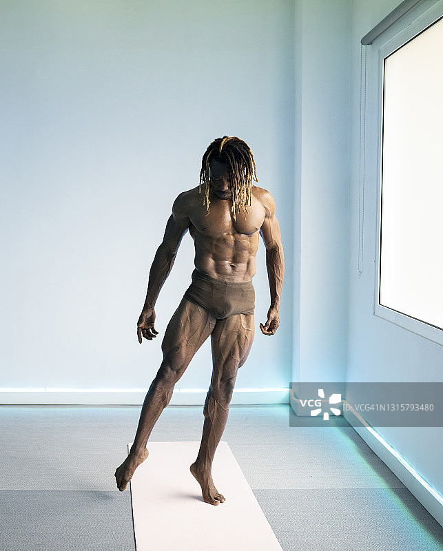 未穿肌肉装的黑人男子做芭蕾舞姿势图片素材