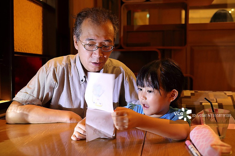 儿童向父亲展示手绘图画图片素材