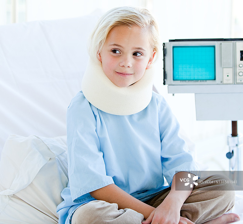 戴着颈托坐在病床上的小女孩图片素材